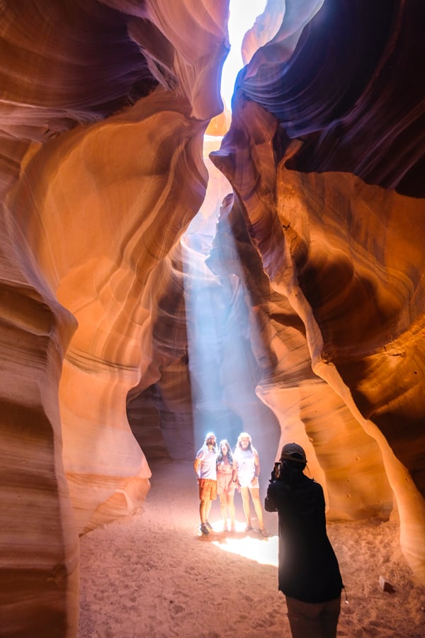 Tourists taking photos in a sunbeam at Upper Antelope Canyon