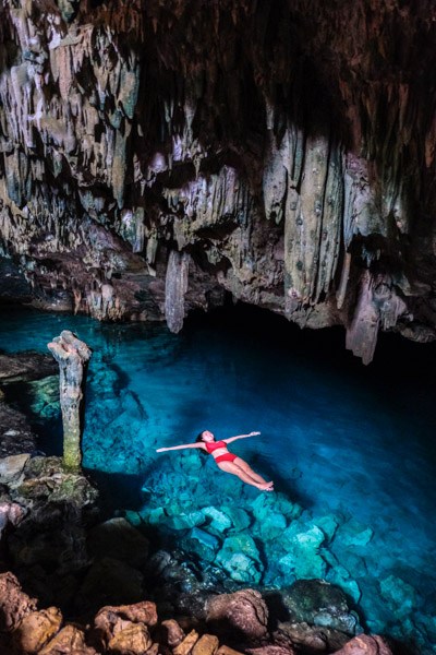 Woman floating in Goa Rangko cave