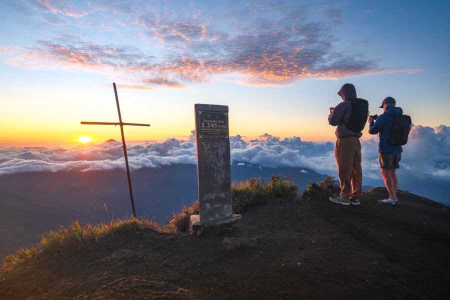 Hikers looking at sunrise at the summit of Mount Inerie