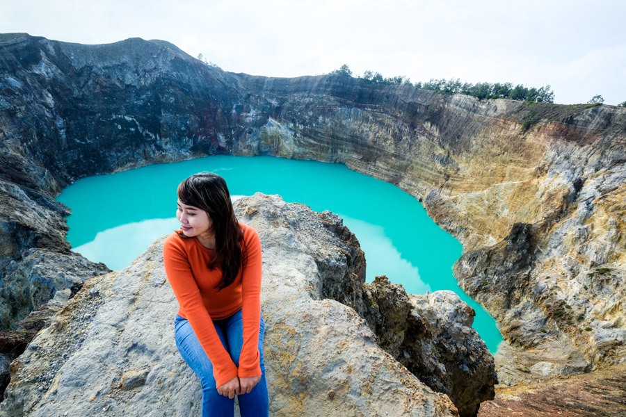 Woman sitting by the Kelimutu blue lake
