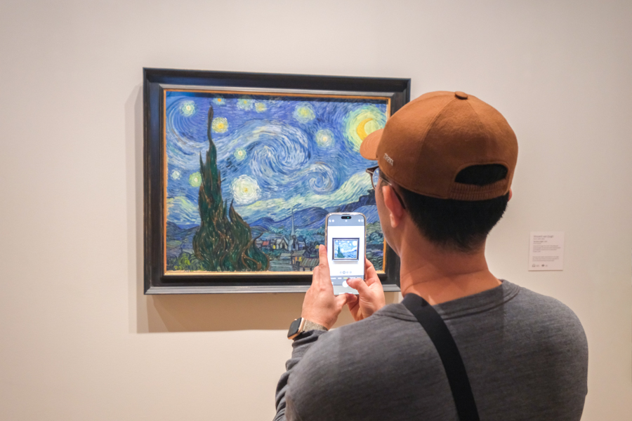 Tourist taking a picture of the Starry Night painting by Van Gogh at the Museum of Modern Art