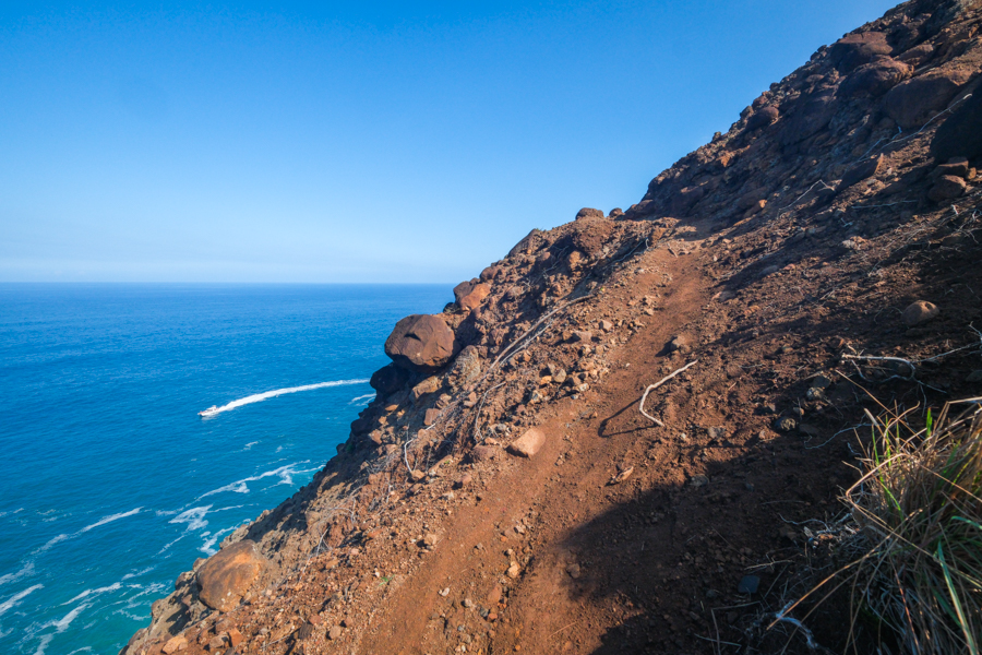 Steep red rock dirt path near the ocean